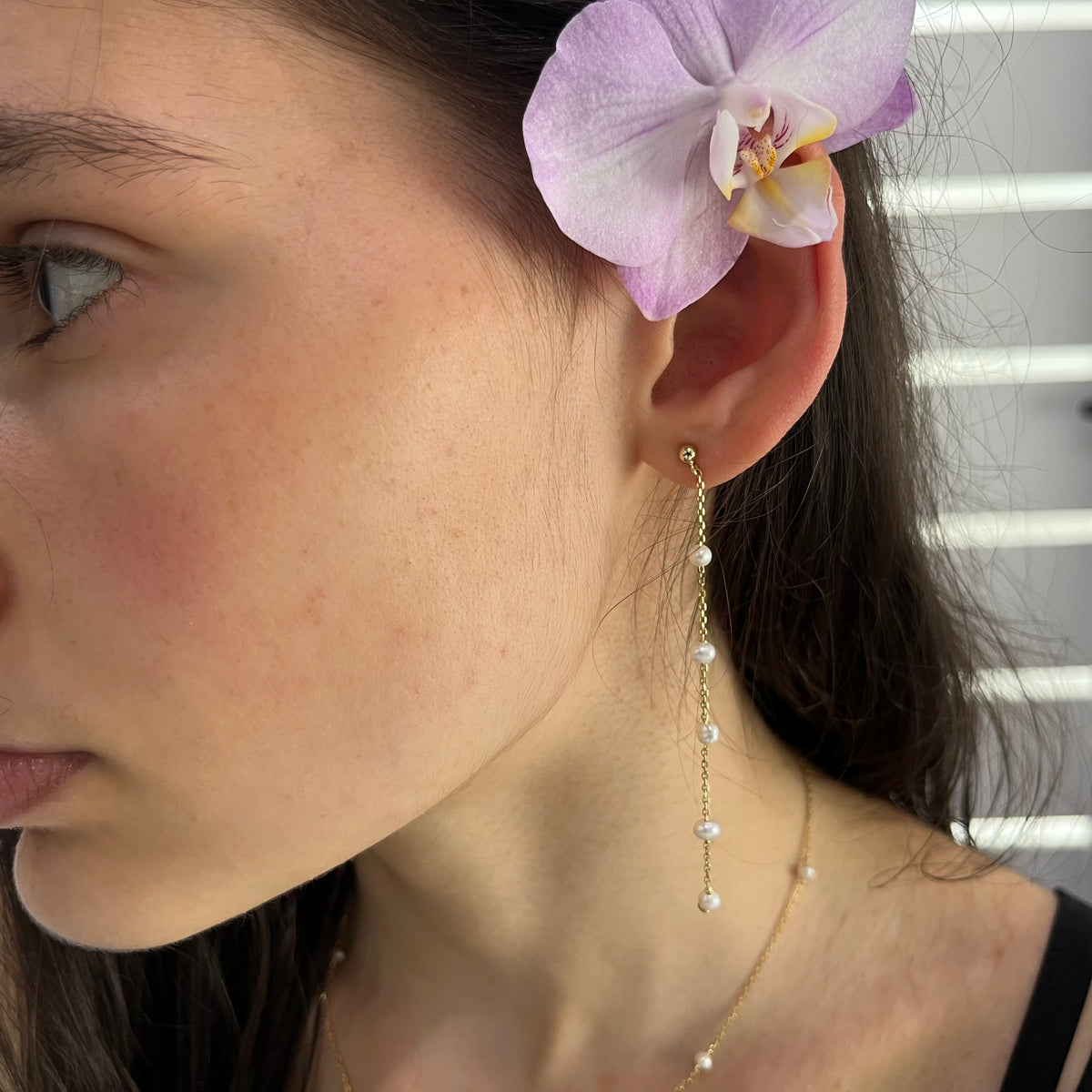 Perlové visiace náušnice Séraphine pri nosení – bočný pohľad s orchideou